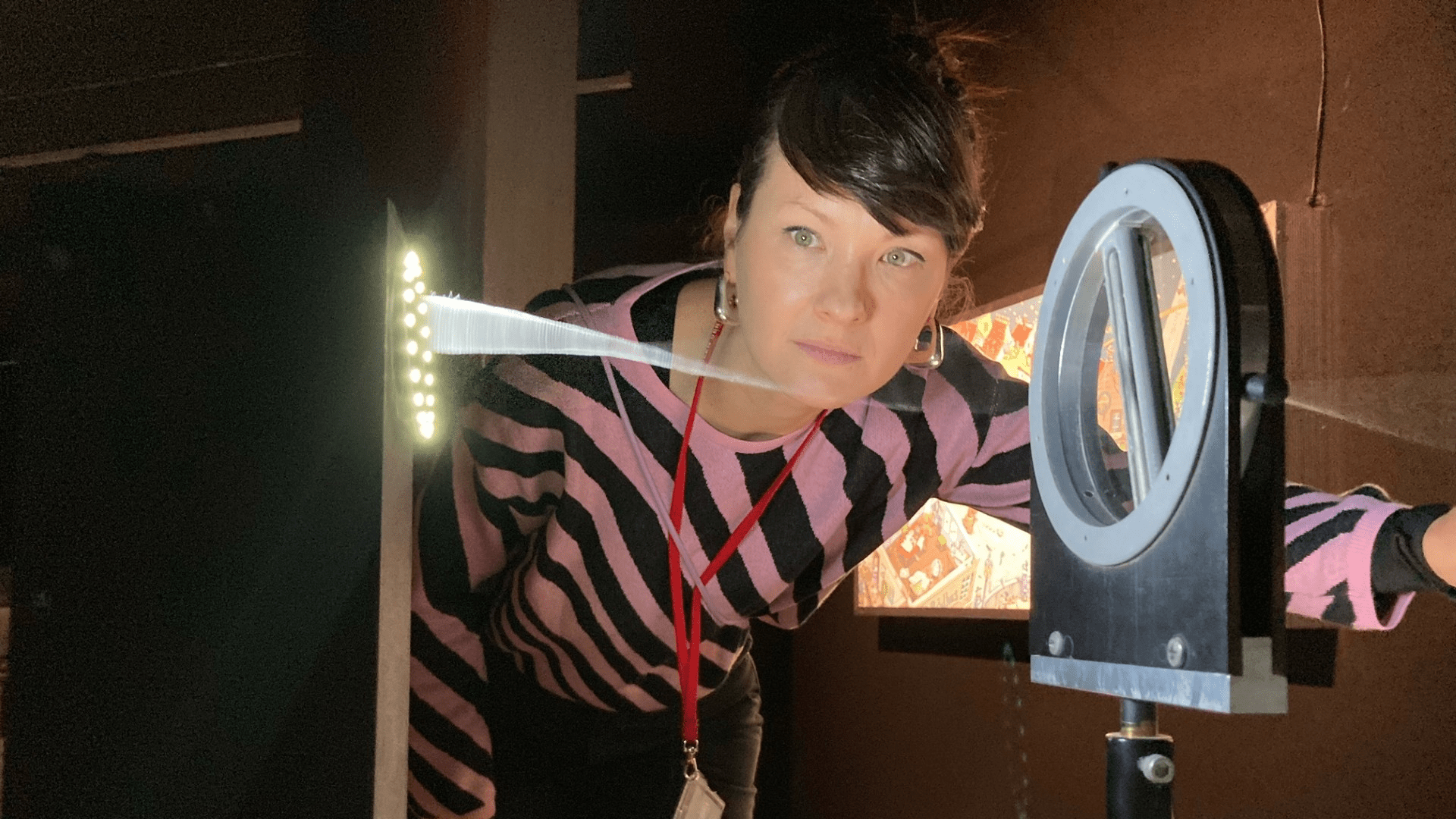 KI generiert: Eine Person beobachtet ein physikalisches Experiment mit optischen Instrumenten, bei dem ein Lichtstrahl durch ein Prisma oder eine Linse gebrochen wird. Der Raum ist schwach beleuchtet, um den Lichtstrahl hervorzuheben.