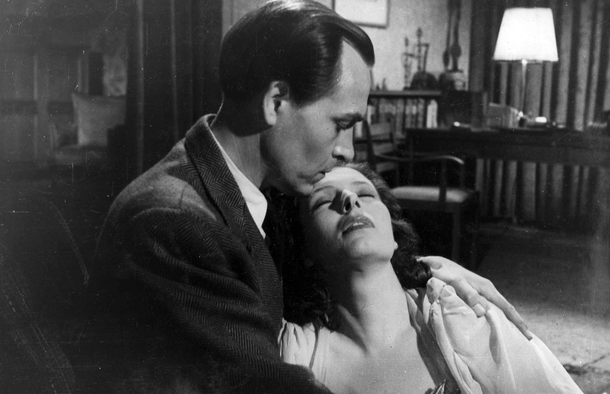 KI generiert: Ein Mann hält eine Frau in seinen Armen und küsst sie sanft auf die Stirn. Die Szene wirkt emotional und intim, als ob sie in einem dramatischen Moment aus einem Film stammen könnte.