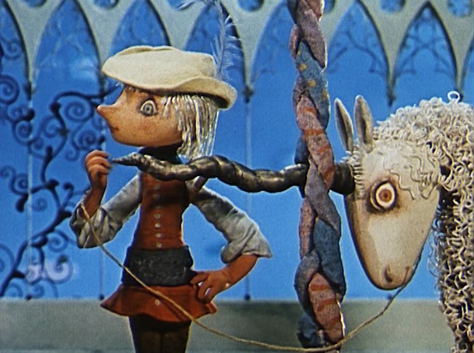 KI generiert: Das Bild zeigt einen puppenhaften Charakter mit einem Hut und einer Feder, der nachdenklich zu einem Einhorn schaut, das mit seinem Horn in einem bunten Stab verfängt ist. Der Hintergrund hat ein verzierendes Muster, das an eine märchenhafte Kulisse erinnert.